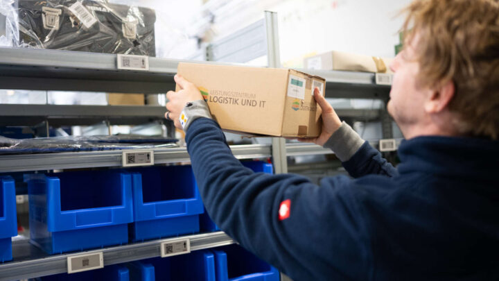 Frau stellt Karton im Picking Lab ins Regal